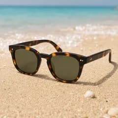 AI product photo: tortoiseshell sunglasses on the sand by the sea